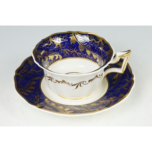 62 - Two 19th century Rockingham porcelain teacups & saucers to include an example decorated with cobalt ... 