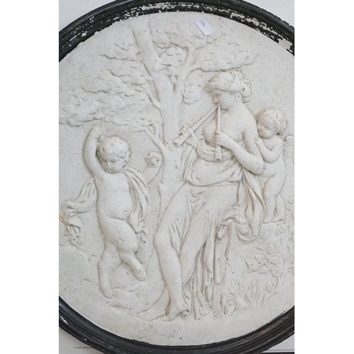 145 - Reconstituted stone circular wall plaque depicting a classical scene of a maiden and two putti. Appr... 