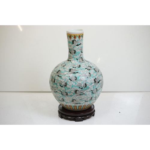 77 - Large Chinese blue ground bottle vase, the enamel decoration depicting cranes in-flight amongst trai... 