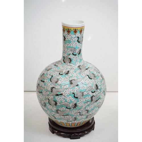 77 - Large Chinese blue ground bottle vase, the enamel decoration depicting cranes in-flight amongst trai... 