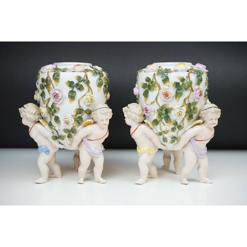 86 - Pair of 19th century Sitzendorf floral encrusted vases, each raised upon three putti (approx 21.5cm ... 