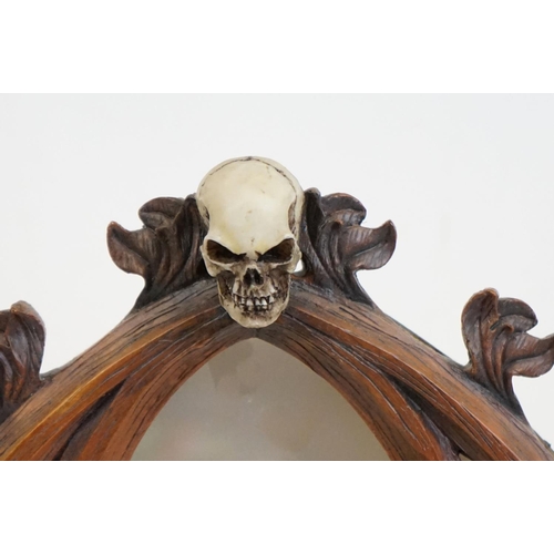 347 - A contemporary gothic style mirror with skeleton decoration.