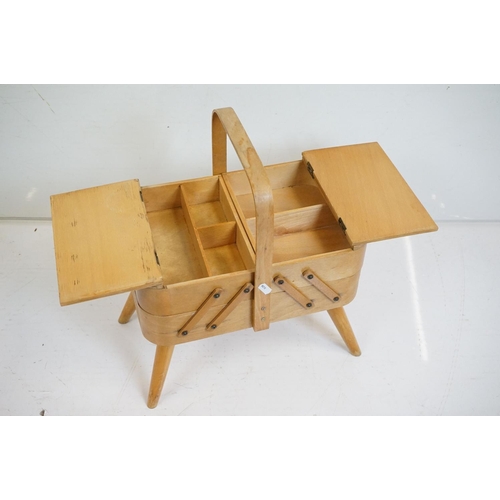 531 - Mid century Beech wood Concertina Sewing Box with carry handle and raised on four turned legs, 36cm ... 