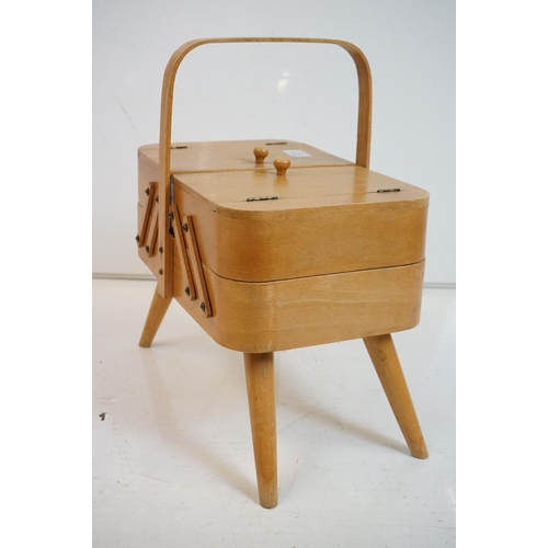 531 - Mid century Beech wood Concertina Sewing Box with carry handle and raised on four turned legs, 36cm ... 