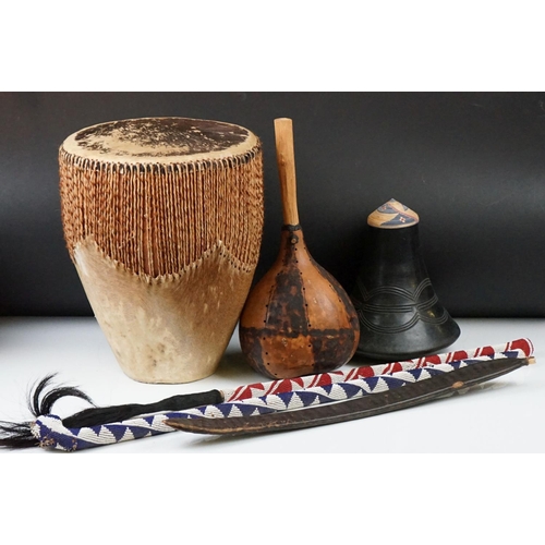 316 - A group of African tribal collectables to include a drum, marriage stick, fly whisk and musical inst... 