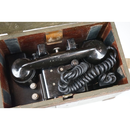 325 - A British military field telephone in original battlefield green storage case.