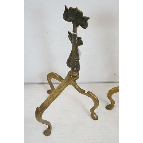 333 - A pair of Art Nouveau brass fire dogs the stylised floral decoration together with brass companion s... 