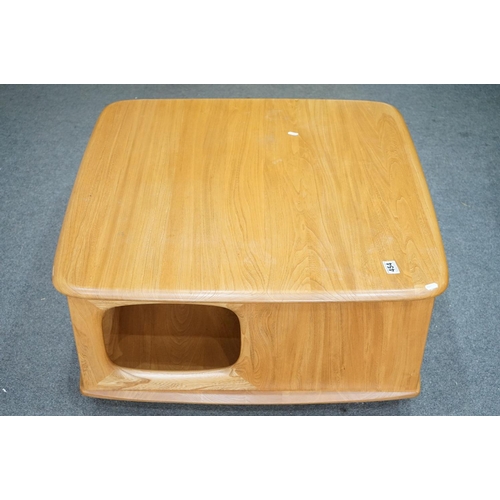 454 - Ercol Pale Elm ' Pandora's Box ' Square Coffee Table with under-shelf and two drawers, raised on cas... 