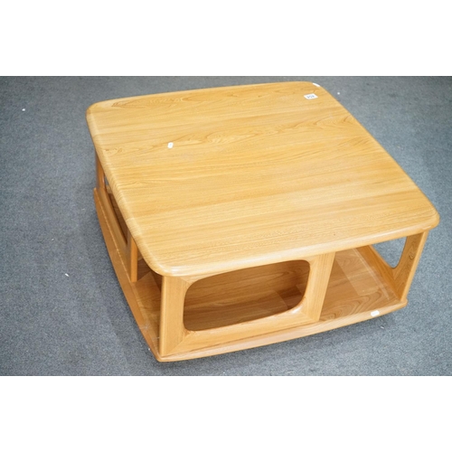 454 - Ercol Pale Elm ' Pandora's Box ' Square Coffee Table with under-shelf and two drawers, raised on cas... 