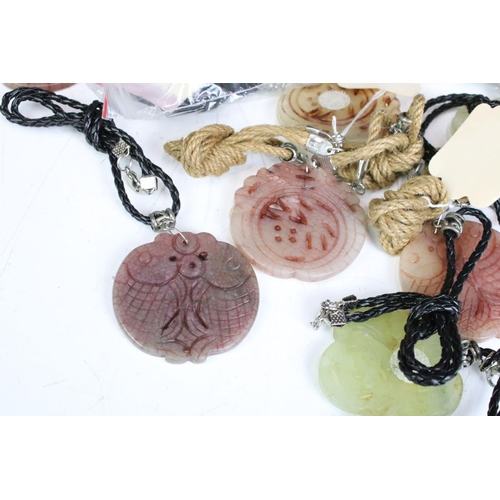 305 - A collection of twenty seven carved jade pendants on leather / hessian necklaces.