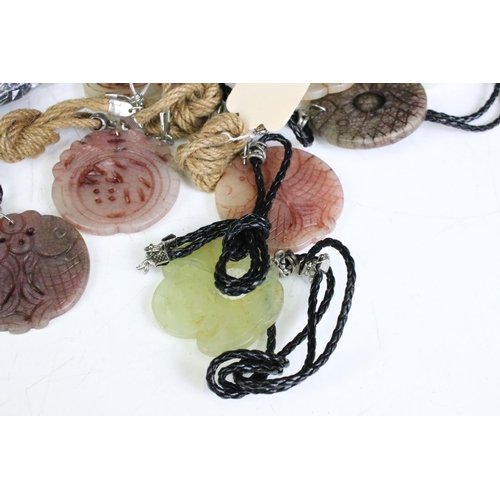 305 - A collection of twenty seven carved jade pendants on leather / hessian necklaces.