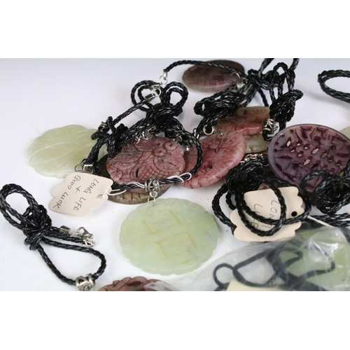 305 - A collection of twenty seven carved jade pendants on leather / hessian necklaces.