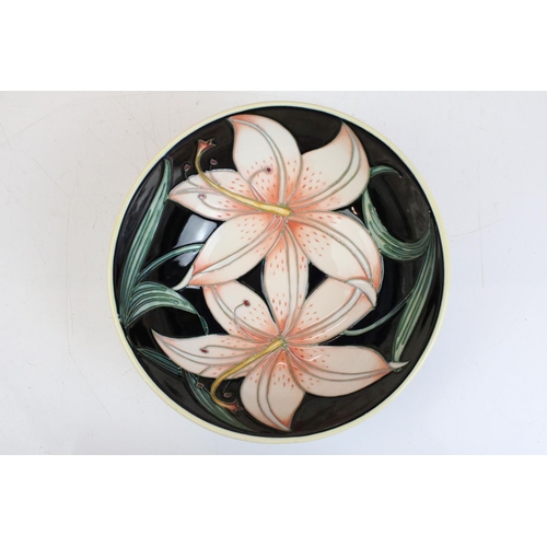 14 - Moorcroft - a small bowl with tube lined lily detailing on a black background. Impressed Moorcroft m... 