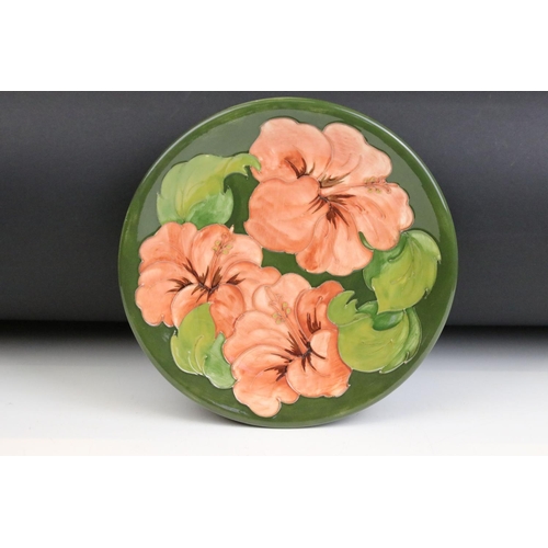 20 - Moorcroft - A Hibiscus pattern tube lined plate together with a small tube lined vase decorated with... 