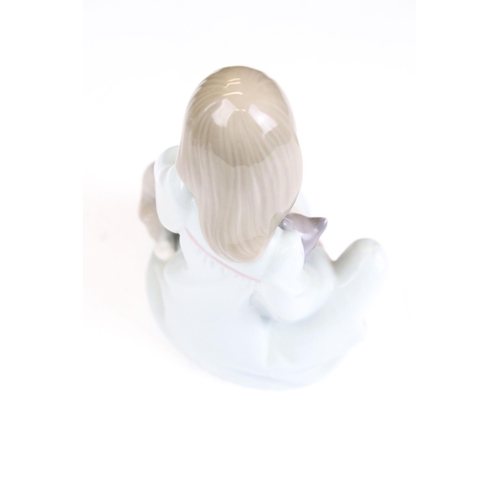 74 - Four Lladro ceramic figurines to include a sleeping baby, swan, girl with puppies and yawning boy. A... 