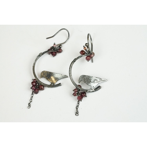 223 - A pair of white metal ladies drop earrings with bird decoration.