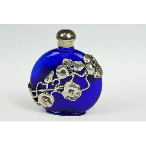 237 - A blue glass scent bottle with white metal floral decoration.