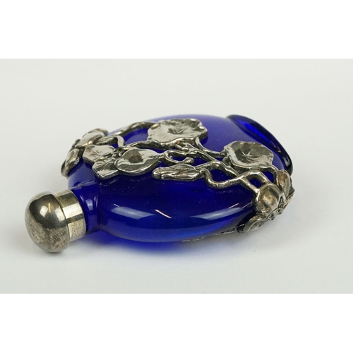 237 - A blue glass scent bottle with white metal floral decoration.