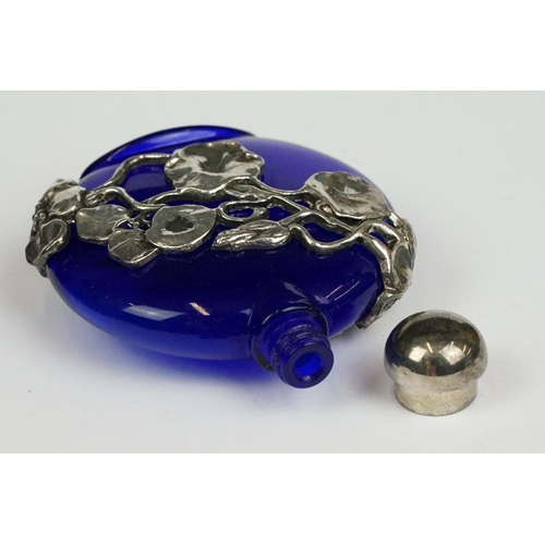 237 - A blue glass scent bottle with white metal floral decoration.