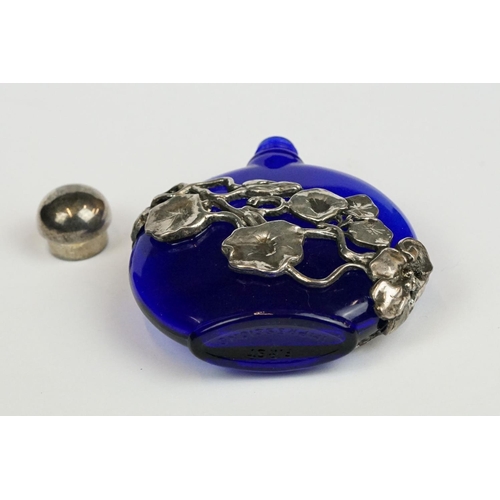 237 - A blue glass scent bottle with white metal floral decoration.