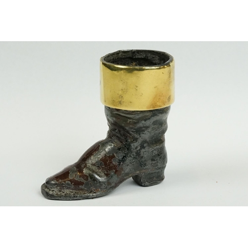 238 - A cast metal match striker in the form of a boot with brass surround.