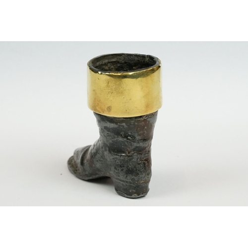 238 - A cast metal match striker in the form of a boot with brass surround.