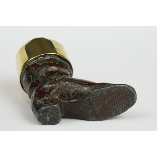 238 - A cast metal match striker in the form of a boot with brass surround.