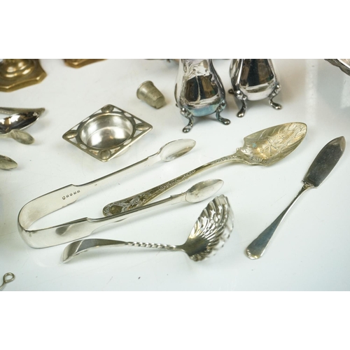 263 - A small collection of mixed silver plate to include teapot, spoons, thimbles, sugar shaker, taper st... 