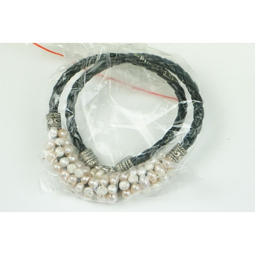 283 - Large collection of natural pearl leather bracelets of varying colours.