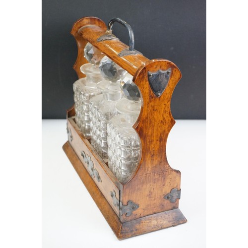 163 - An antique oak tantalus with silver plated mounts with three glass decanters.