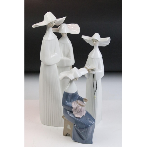 35 - Group of three Lladro figurines in the form of nuns, to include one group figurine and two individua... 