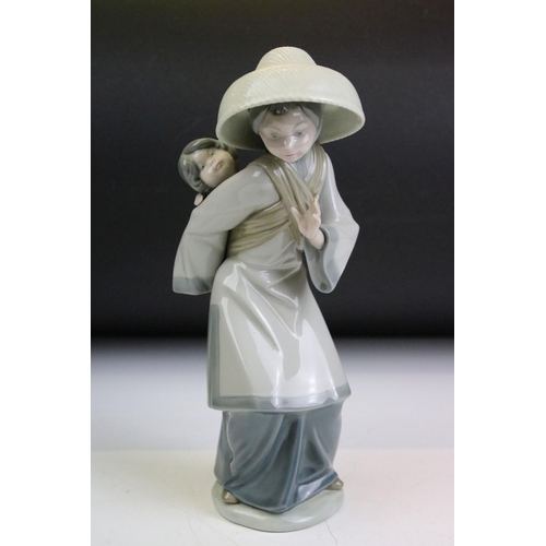 53 - Lladro figurine in the form of a lady with a baby strapped to her back, a 19th Century plate with a ... 