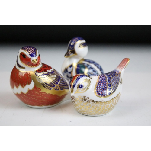 55 - Group of three Royal Crown Derby ceramic paperweights to include two birds with gold stoppers and on... 