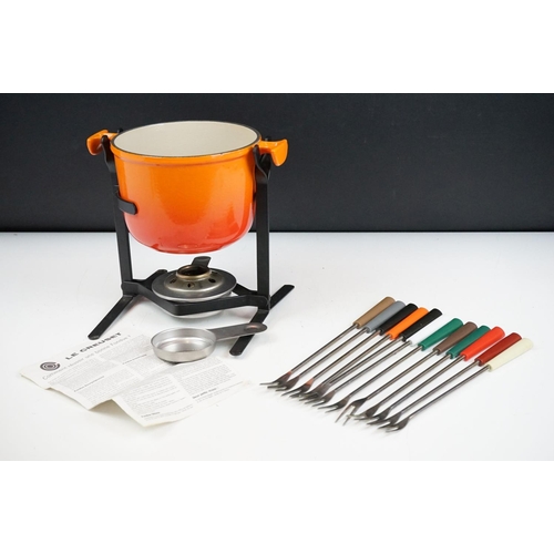 126 - Le Creuset cast iron fondue set complete with stand, burner and twelve sticks. Measures 21 x 22cm.