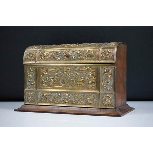 132 - An early 20th century wooden letter rack with brass art nouveau repousse decoration.