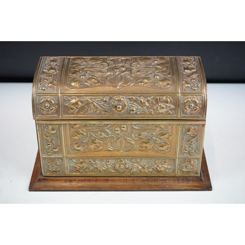 132 - An early 20th century wooden letter rack with brass art nouveau repousse decoration.