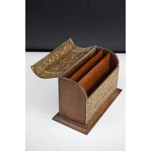 132 - An early 20th century wooden letter rack with brass art nouveau repousse decoration.