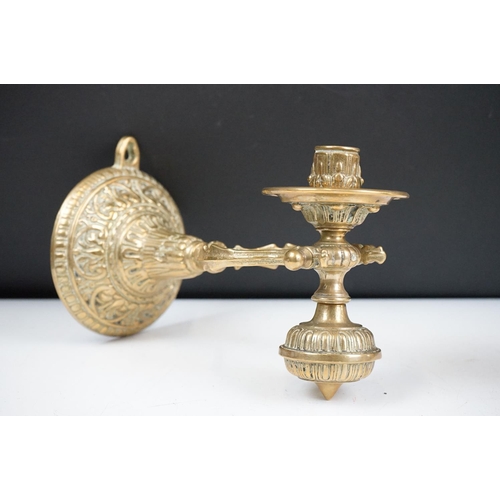 144 - A pair of brass standing or wall mounted candlesticks with gimble mounting.