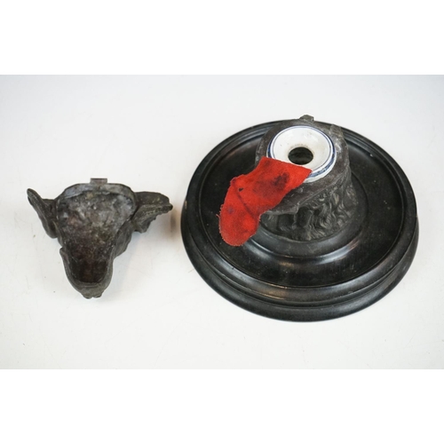 146 - A Victorian pewter inkwell in the form of a dogs head mounted on a turned black wooden base, complet... 