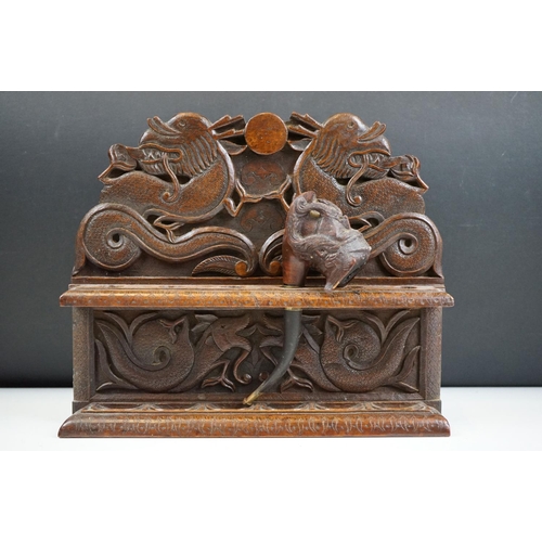 147 - An oriental carved wooden pipe rack with dragon decoration together with a pipe with Viking bowl.