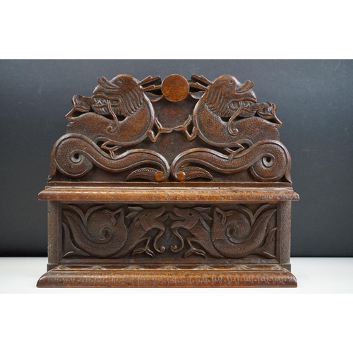 147 - An oriental carved wooden pipe rack with dragon decoration together with a pipe with Viking bowl.