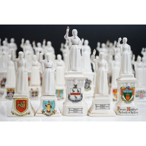 94 - 35 ceramic crested ware / goss figurines of Florence Nightingale, each with a town crest to the fron... 