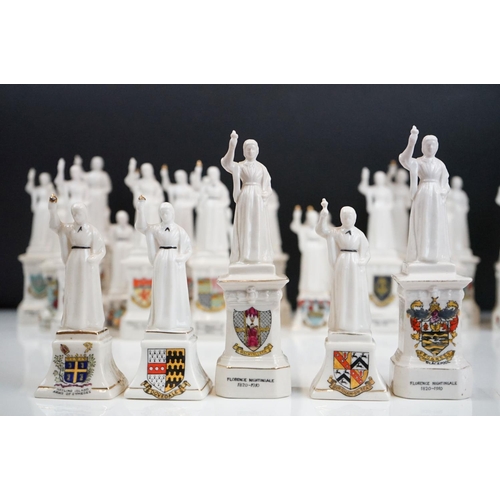 94 - 35 ceramic crested ware / goss figurines of Florence Nightingale, each with a town crest to the fron... 