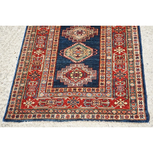 585 - Eastern Red and Blue Ground Wool Runner Rug decorated with thirteen guls within a deep border, appro... 