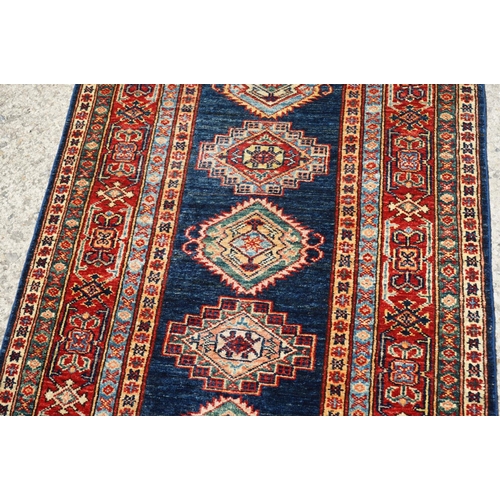 585 - Eastern Red and Blue Ground Wool Runner Rug decorated with thirteen guls within a deep border, appro... 