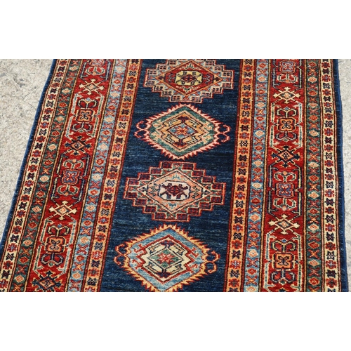 585 - Eastern Red and Blue Ground Wool Runner Rug decorated with thirteen guls within a deep border, appro... 