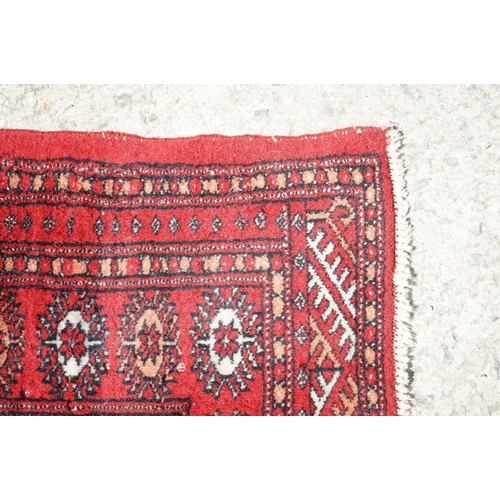 596 - Eastern Red Ground Wool Rug decorated with a row of ten guls within a border, approx. 190cm x 130cm