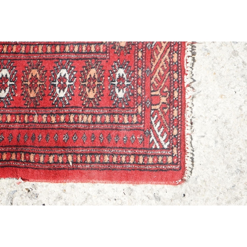 596 - Eastern Red Ground Wool Rug decorated with a row of ten guls within a border, approx. 190cm x 130cm