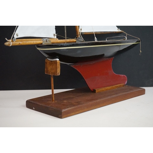 158 - A vintage wooden pond yacht complete with stand.