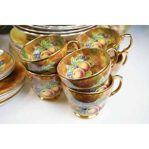 51 - Baroness china dinner service featuring painted peach and grape motifs and gilt rims. Signed A Mello... 